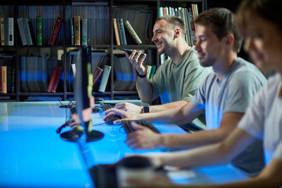 Photo of multiple people working in a digital agency on a desk.